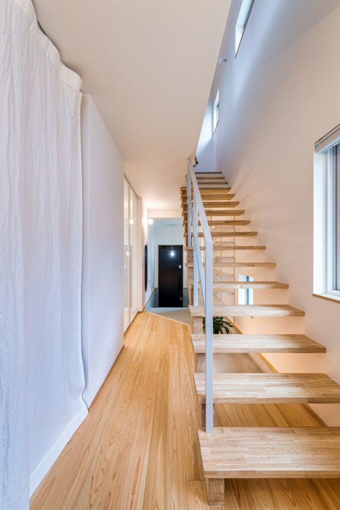 開放感のあるストリップ階段と明るいヒノキの床