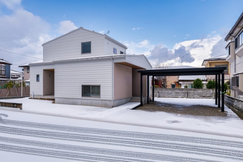 さんかく屋根とグレージュの塗り壁